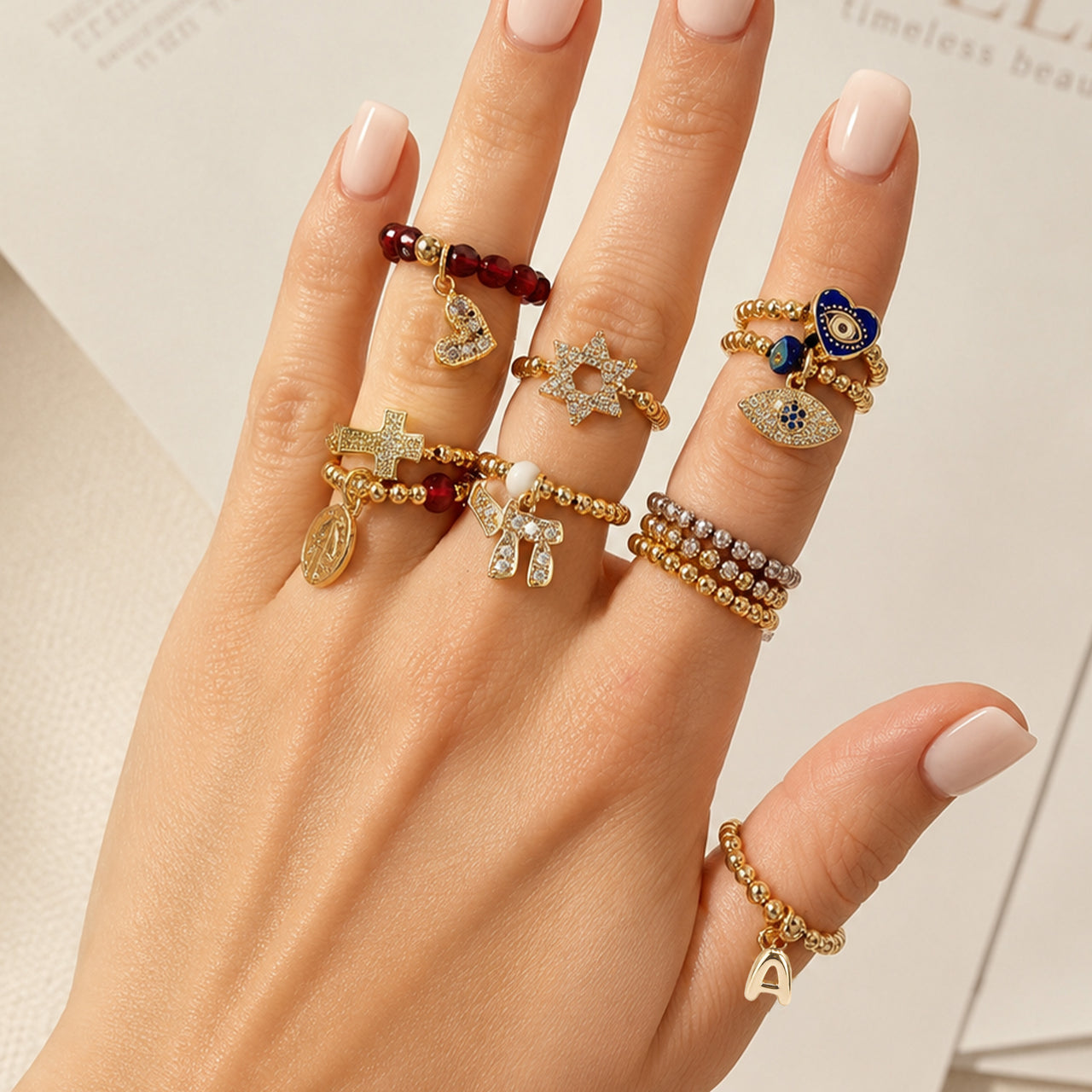 Love Lisa Noa Luxe Chai Stretch Ring worn in a stack with gold and silver beaded rings and Judaica charm details