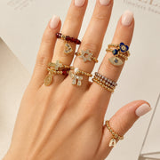 Love Lisa Noa Luxe Chai Stretch Ring worn in a stack with gold and silver beaded rings and Judaica charm details