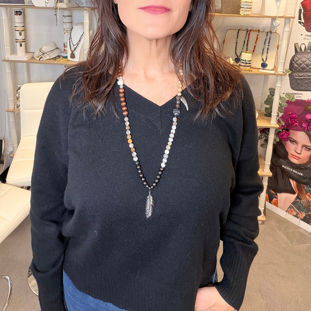 model wearing feather buddha gemstone wrap necklace bracelet close up jasper beads buddha bead feather charm and black worry stone heart