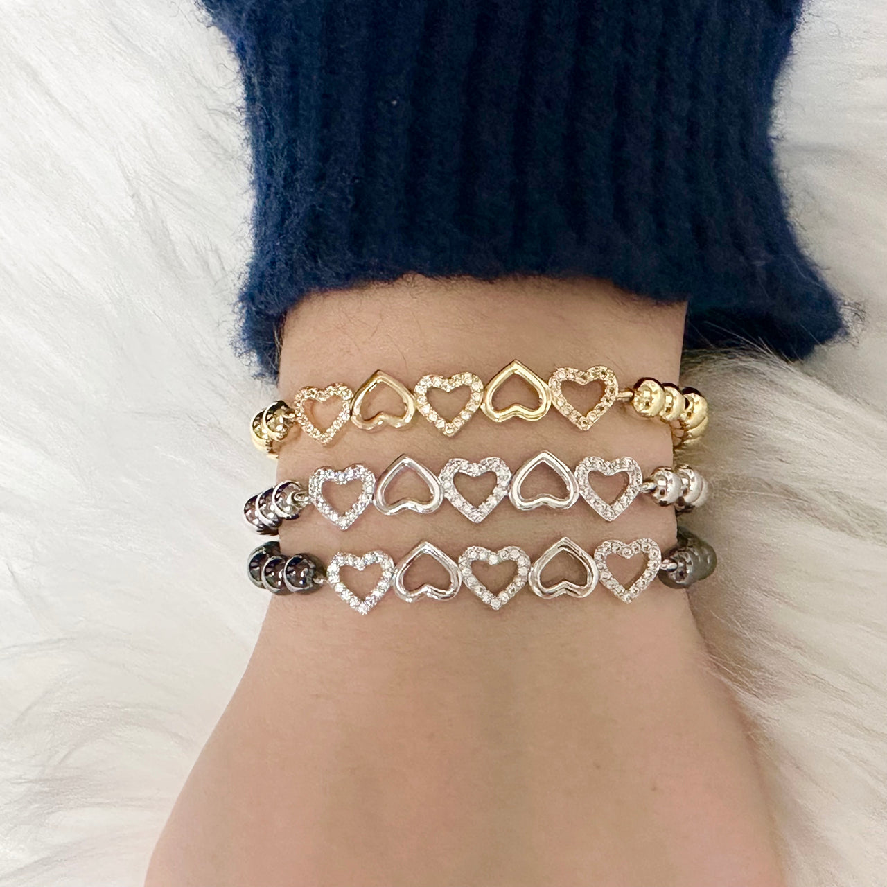 Love Lisa Five Hearts of Grace Bracelet shown on wrist with layered bracelets

