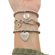 love lisa forever in my heart bracelet stack worn on wrist with saint charm pave heart and engraved charm