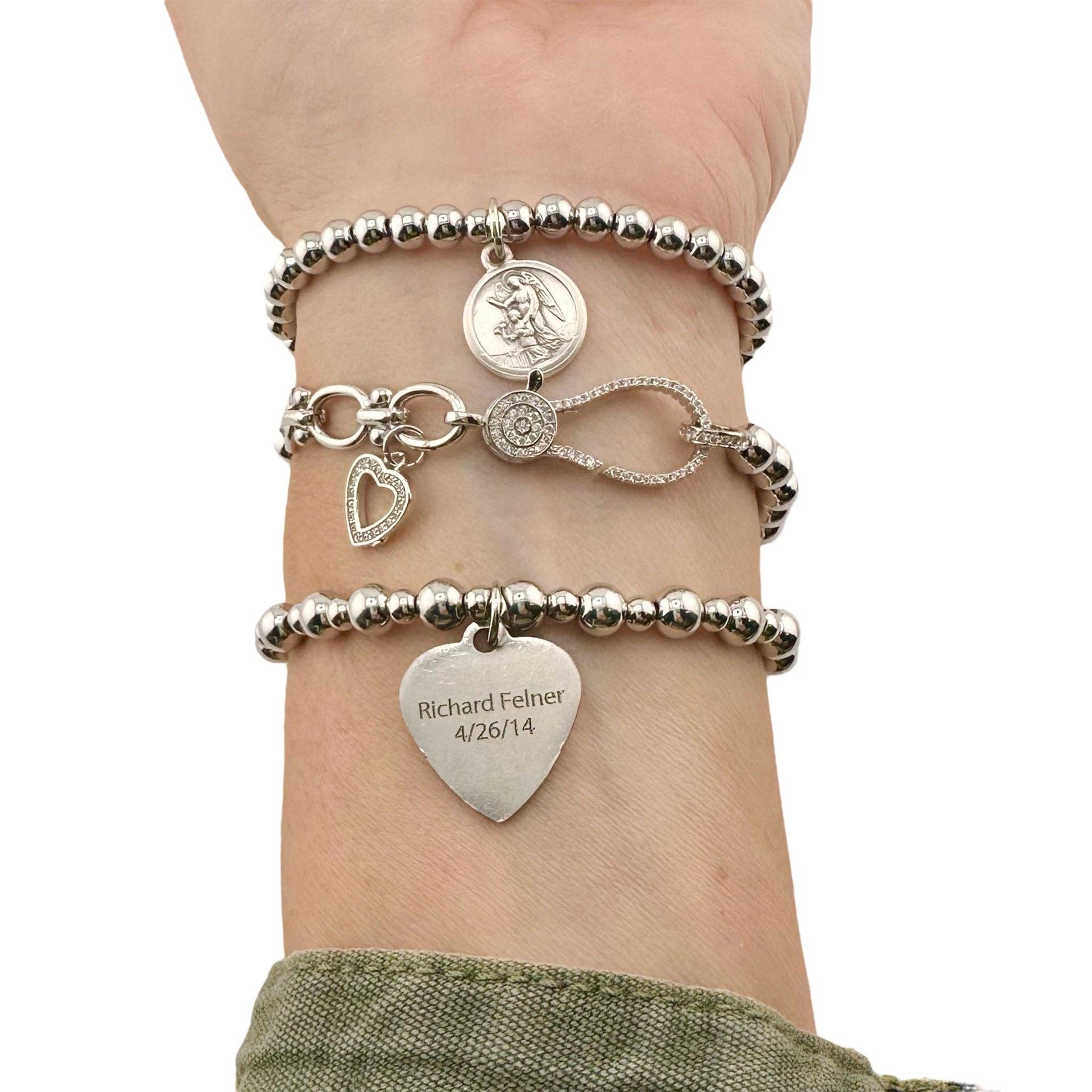 love lisa forever in my heart bracelet stack worn on wrist with saint charm pave heart and engraved charm