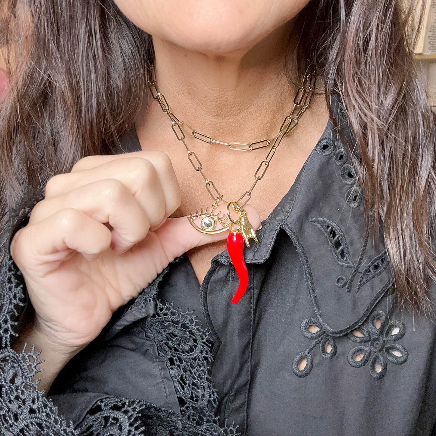 lisa is wearing the gianna necklace with the evil eye the mano and the italian horn showing it close up
