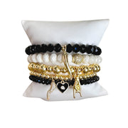 A set of beaded bracelets with gold, black, and white colors, featuring Italian horn charms and other decorative elements.