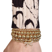 model wearing gold bow charm bracelet love lisa layered beaded bracelet stack trendy jewelry