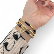 model wearing love lisa gold glam family bracelet stack with mom charms and meaningful heart charm