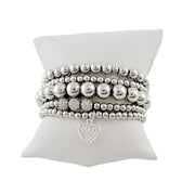 Silver stack of bracelets with a pave heart charm