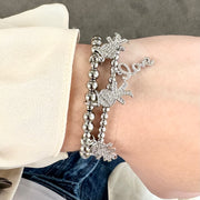 woman wearing silver grandma bracelet with grandchildren charms