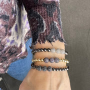 woman wearing gold beaded bracelet with silver pave beads