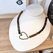 Necklace with heart clasp on a white stand with a wooden surface background