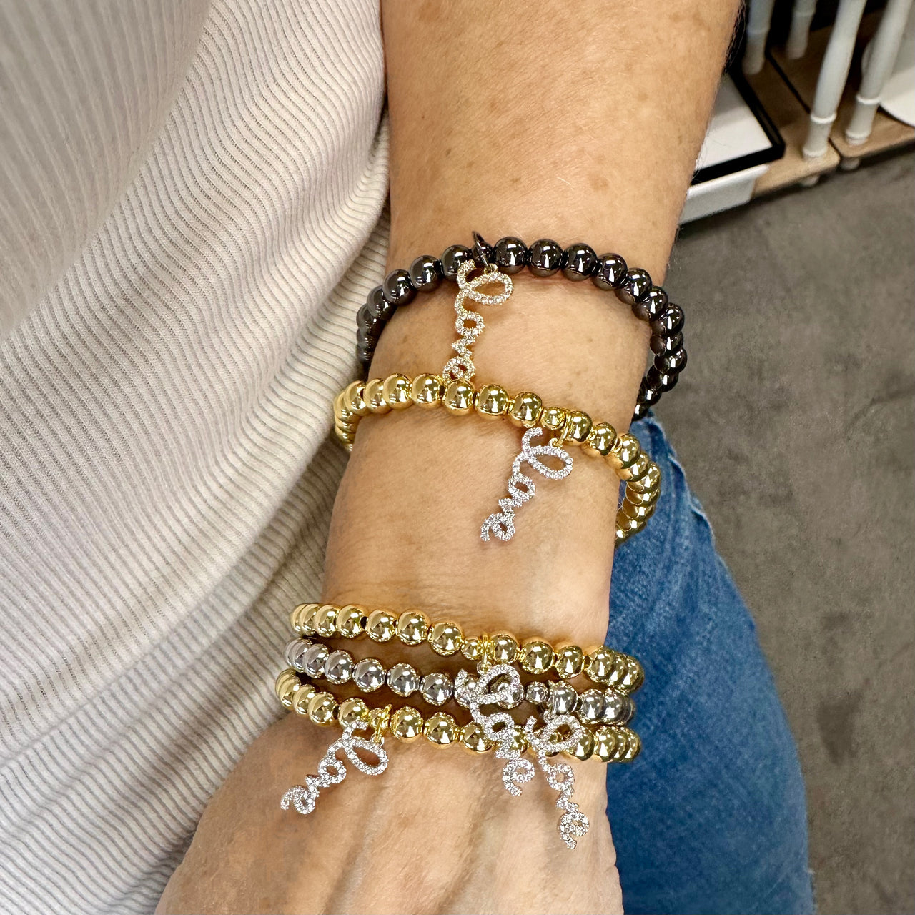 woman wearing hailey love bracelet stacked gold and silver beaded bracelets