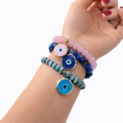Love Lisa Hailey pink Murano Glass Evil Eye Bracelet worn in a colorful wrist stack with faceted glass beads and protective evil eye charms