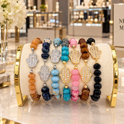 Love Lisa Hamsa Mixed Gemstone Beaded Bracelets displayed together in Beige, Navy, Light Blue, Turquoise, Pink, Brown, and Black with gold-tone and silver-tone pavé Hamsa centerpieces