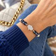 Love Lisa navy Hamsa gemstone bracelet worn on the wrist with patterned cream and blue gemstone beads, faceted navy Czech glass rondelles, and a sparkling silver-tone Hamsa centerpiece