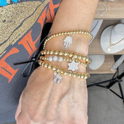 love lisa model wearing hanukkah judaica charm bracelet stack gold beads with chai hamsa and star of david charms