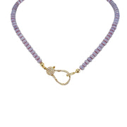 A purple beaded necklace with a gold pave clasp.