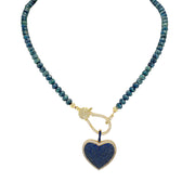 A blue beaded necklace with a gold pave clasp.