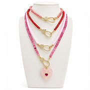 Love Lisa Harper Crystal Clasp Necklaces layered on display in pink and red crystal bead colors with gold easy open clasps and heart charm styling