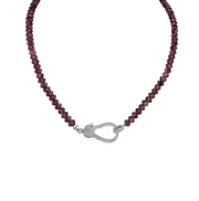 A plum beaded necklace with a gold pave clasp.