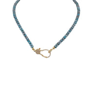 A blue beaded necklace with a gold pave clasp.