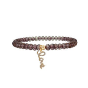 Beaded bracelet with a gold love charm on a white background