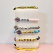 evil eye name bracelets displayed with gold and silver letter beads