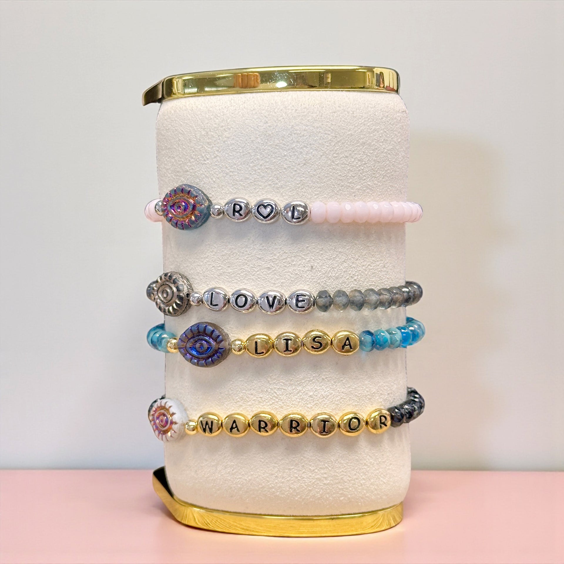 evil eye name bracelets displayed with gold and silver letter beads