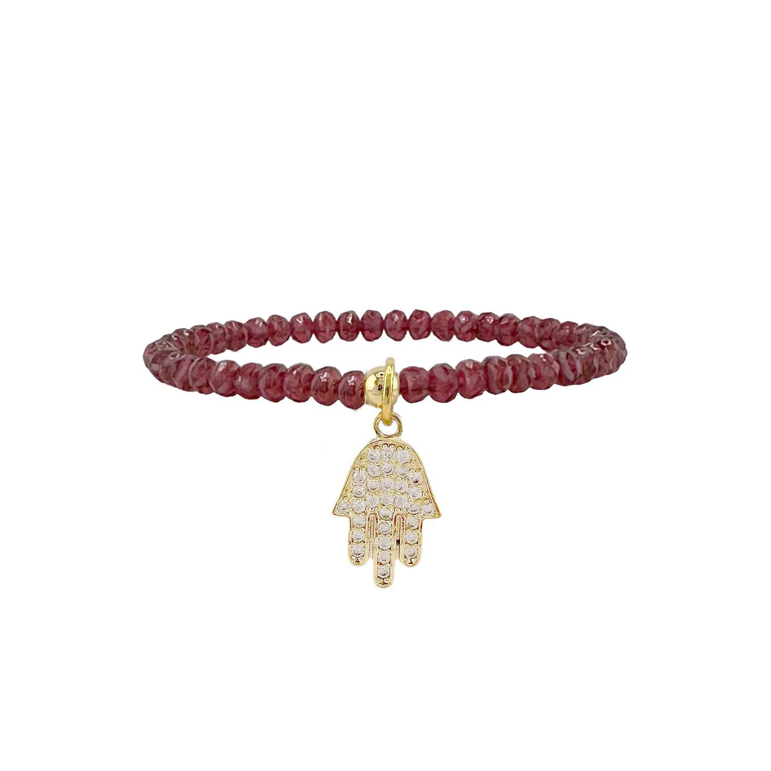 Bracelet with red beads and gold Hamsa hand charm on a white background