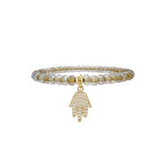 Bracelet with beaded design and gold Hamsa hand charm on a white background