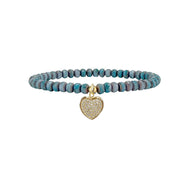 Bracelet with turquoise beads and a gold heart-shaped charm on a white background