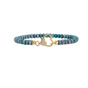 Turquoise beaded bracelet with a gold heart clasp on a white background