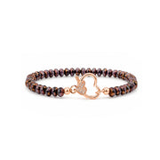 A beaded bracelet with dark brown and black iridescent beads, featuring a rose gold heart-shaped clasp with a small crystal accent, shown on a plain white background.