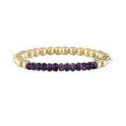 Bracelet with gold beads and purple stones on a white background