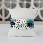 love lisa harper-meaningful moments bracelet stack blue beaded word bracelets happy family loved blessed grateful on pillow display