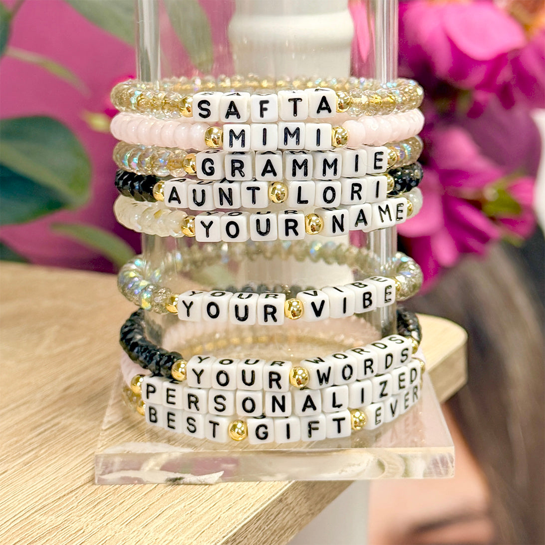 love lisa display stand with multiple harper personalized word bracelets stacked in assorted colors with white letter beads