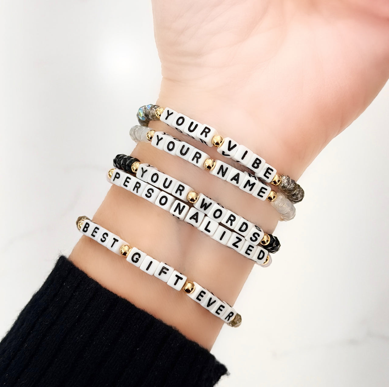 love lisa harper personalized word bracelets stacked on wrist with assorted crystal colors and custom white block letter names