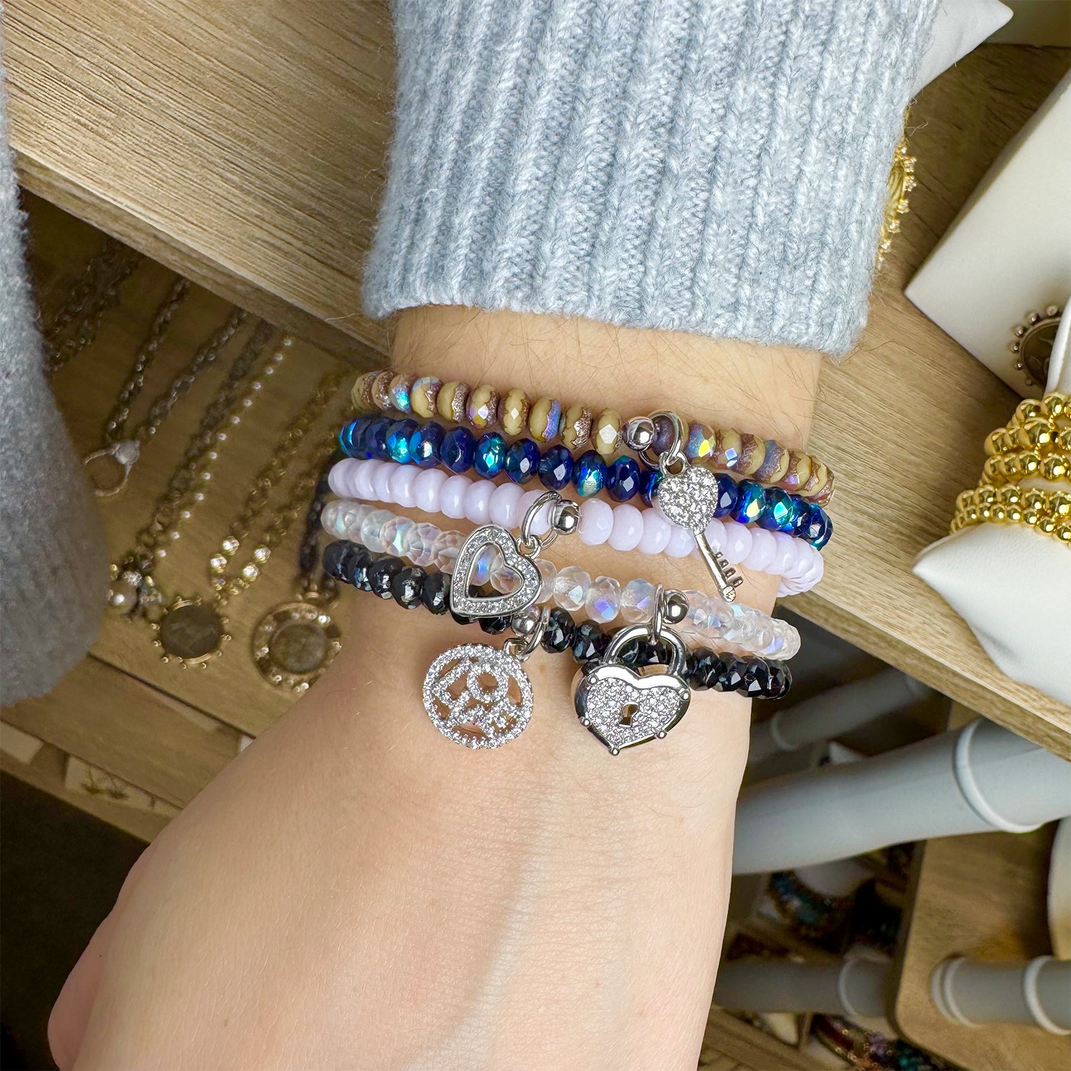 Love Lisa layered crystal bracelet stack with heart lock key and LOVE charms worn on wrist