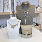 pearl cross necklace styled on model with heart butterfly and mary charms