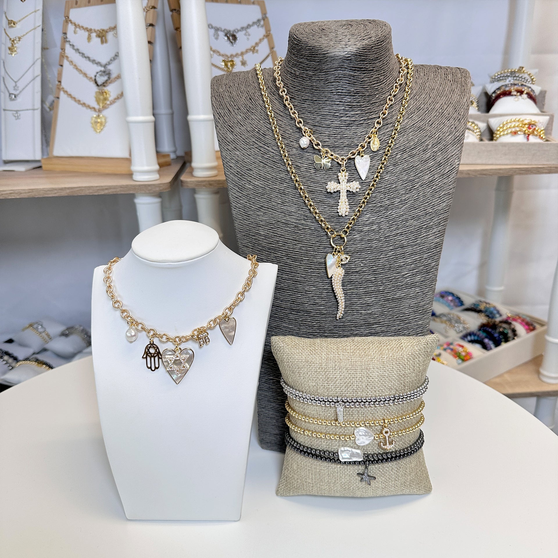 pearl cross necklace styled on model with heart butterfly and mary charms