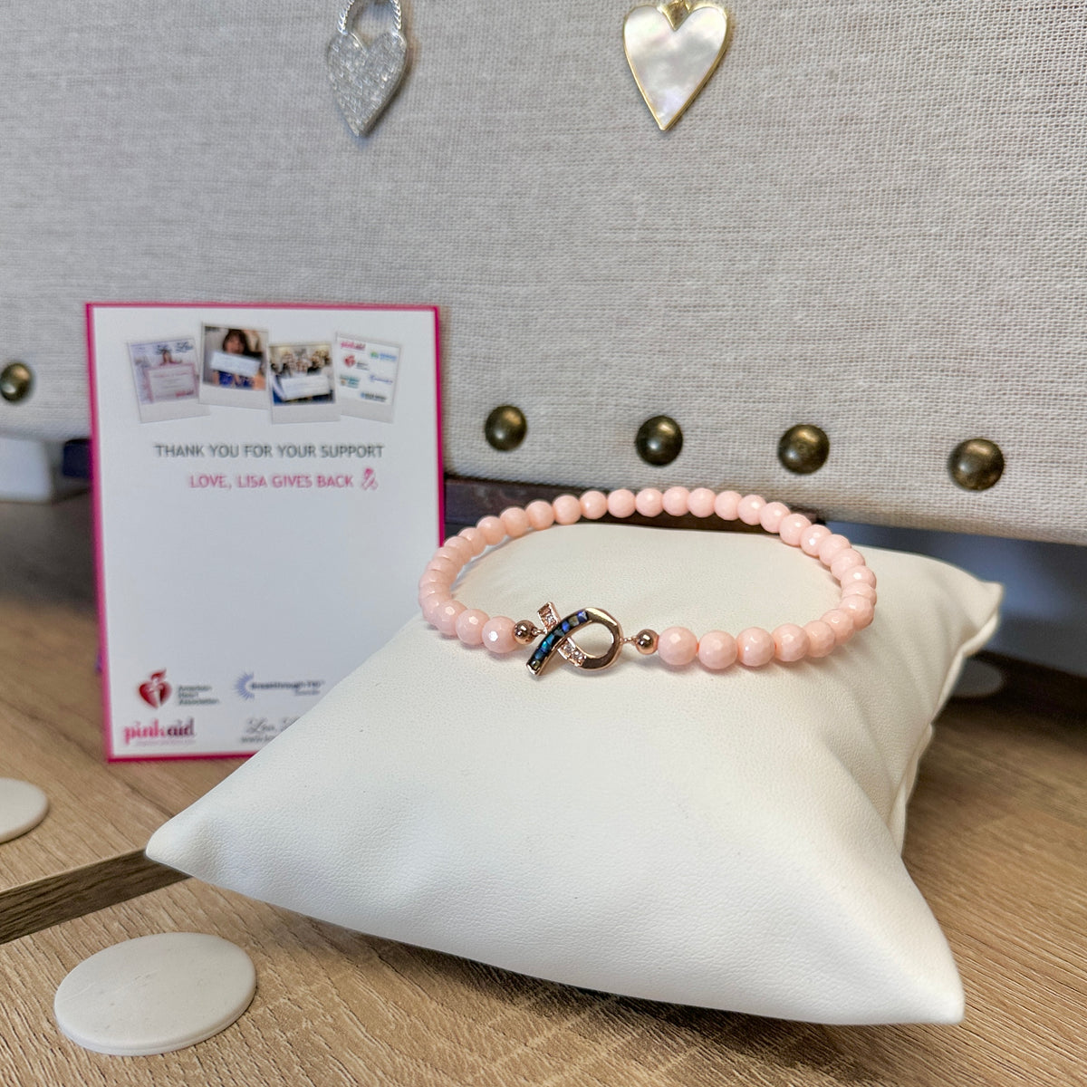 Love Lisa Hope Breast Cancer Awareness Pink Ribbon Anklet displayed on white pillow with pink ribbon charm and awareness card