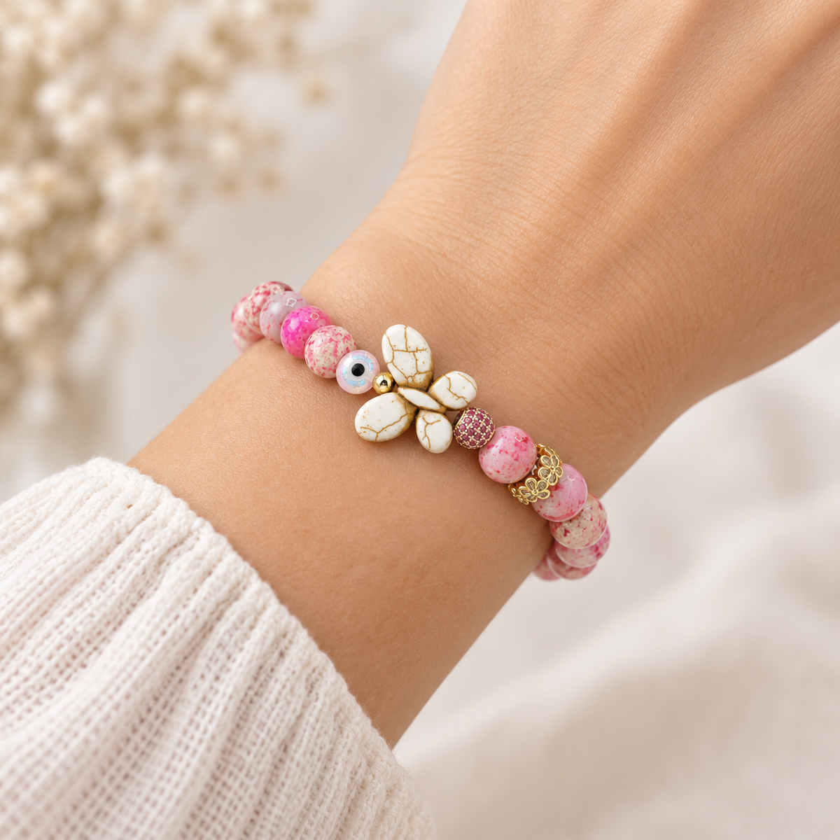 Love Lisa Hope Wish & Wonder Butterfly Bracelet worn on wrist with pink Sea Sediment Jasper beads, white howlite butterfly, evil eye bead, and gold-tone accents