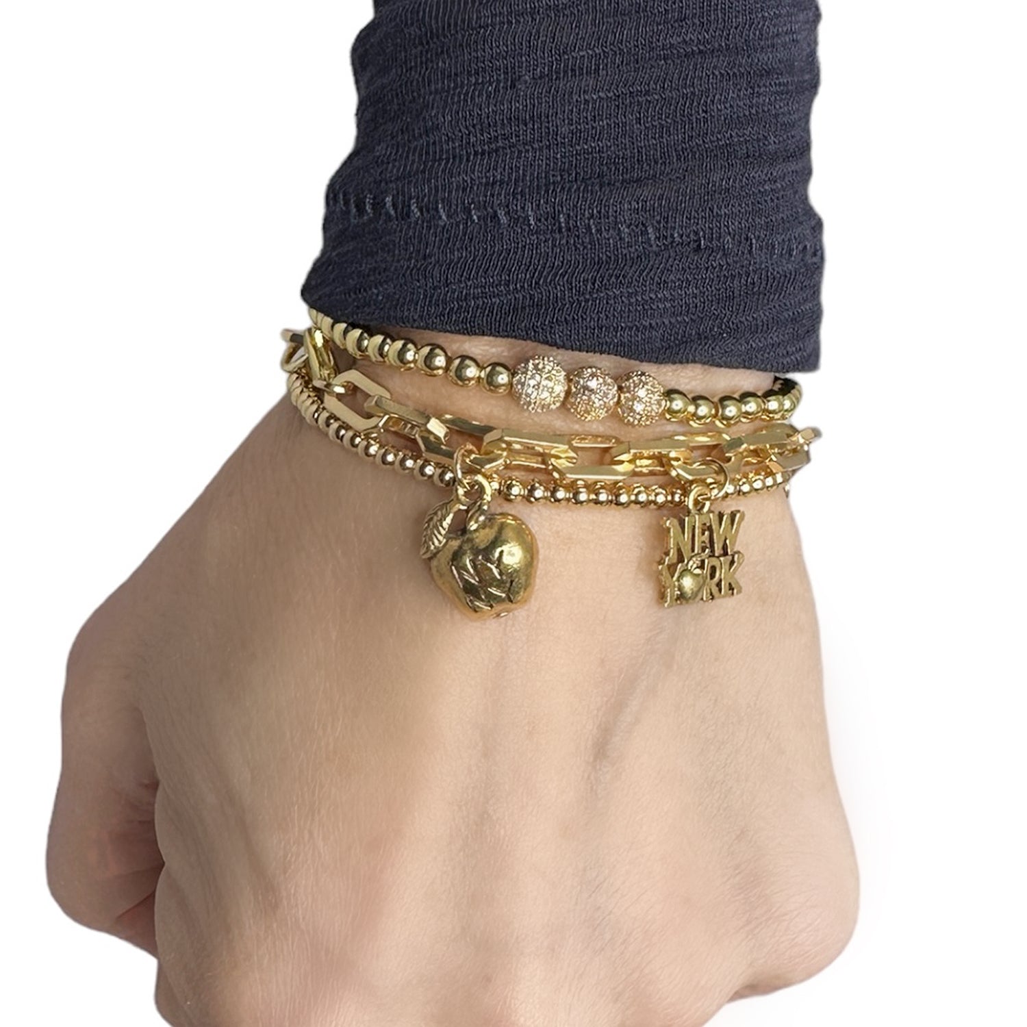 model wearing i love new york charm bracelet with gold nyc icons pretzel subway token and empire state building by Love Lisa