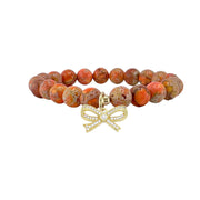 orange sea sediment jasper bow bracelet with earthy orange and tan patterned stones and gold bow charm