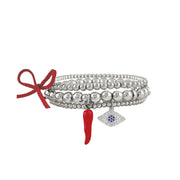Evil eye and italian horn in red charm on this three stack of beaded bracelets