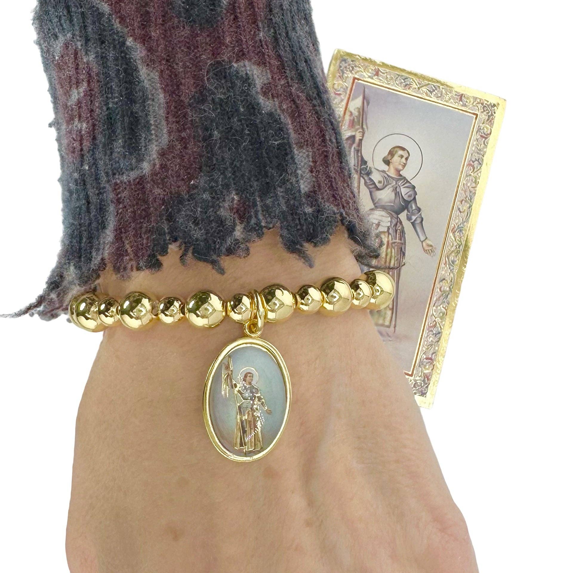 love lisa joan of arc courage bracelet on wrist gold beaded bracelet with joan of arc medal spiritual inspirational jewelry