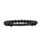 A black bracelet featuring a series of round black lava rock beads, with a sleek black diamond bar design, on a white background.