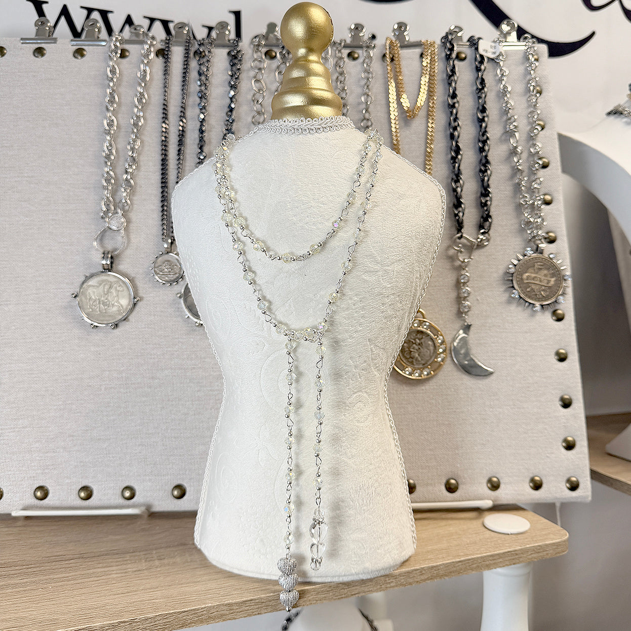 Triple heart crystal lariat necklace displayed on mannequin highlighting 40 inch length and cascading crystal design