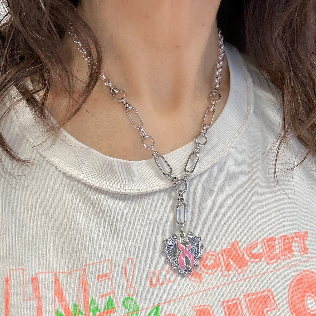 Love Lisa Layla Breast Cancer Awareness Pink Ribbon Necklace worn with Y-link chain, spiked heart pendant, and pink enamel ribbon charm
