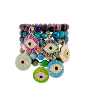Colorful beaded bracelets with eye-shaped charms on a white background