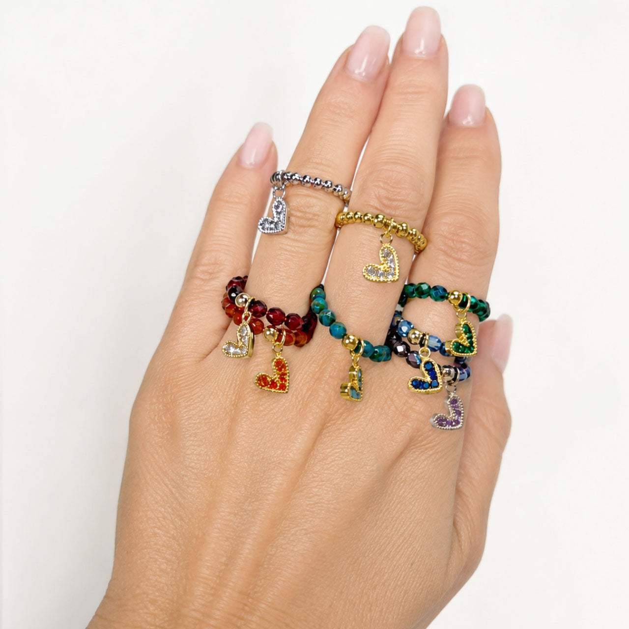 Love Lisa Lexi Slanted Heart Crystal Stretch Rings worn in a colorful ring stack with pavé heart charms